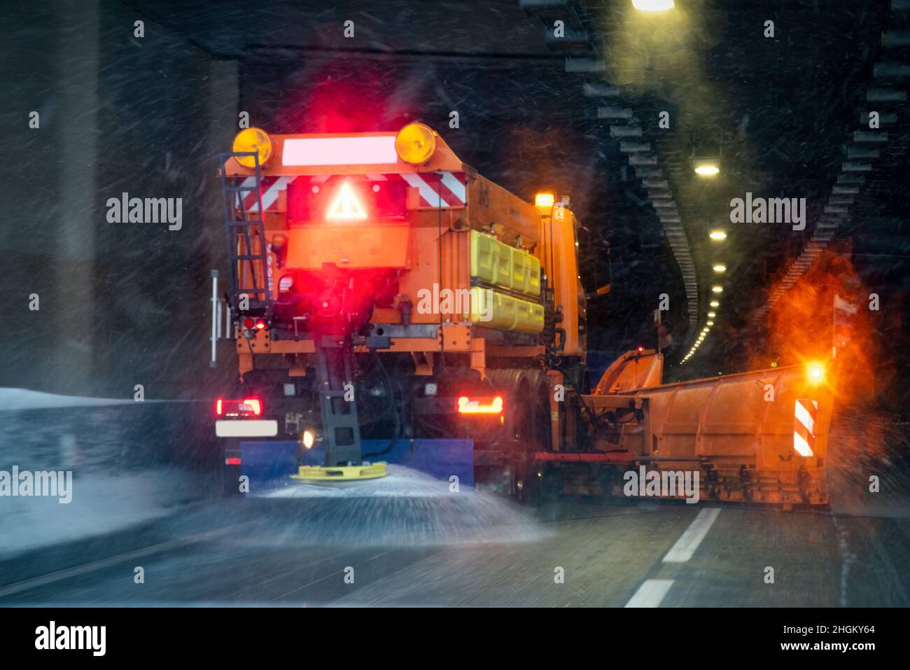 Winterdienstfahrzeug in Arbeit fährt in einen Tunnel. Bild durch Schnee und Salz verschwommen Stockfoto