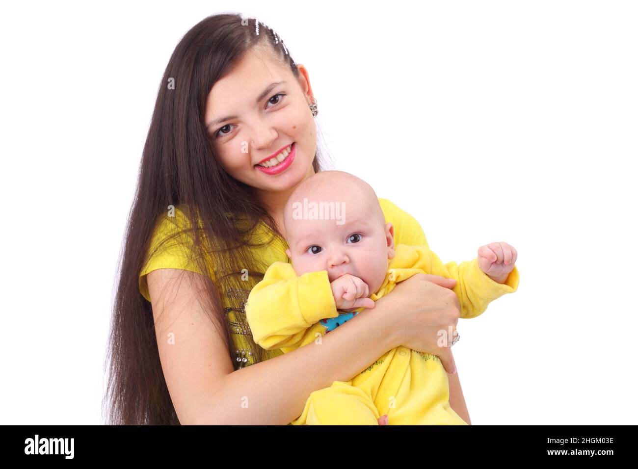 Ziemlich glückliche junge Mutter mit dem niedlichen kleinen Baby in gelber Kleidung Stockfoto