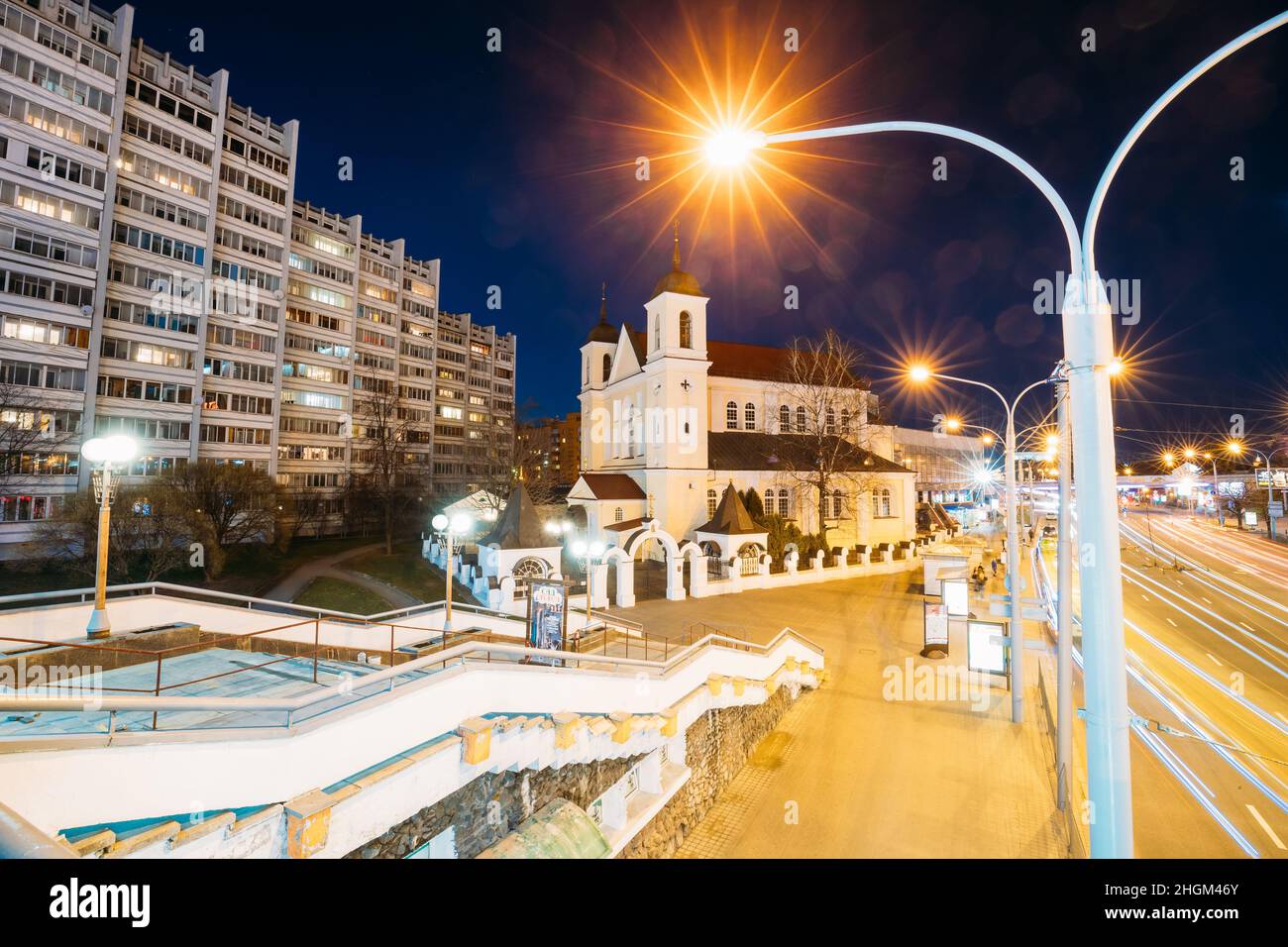 Minsk, Weißrussland. Abendnacht Blick auf die Kathedrale der Heiligen Apostel St. Peter und Paul auf der beleuchteten Nemiga Straße. Der Tempel des Belarussischen Stockfoto