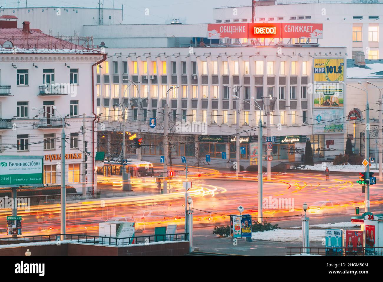 Vitebsk, Weißrussland. Morgenverkehr An Der Kreuzung Der Straßen Lenina Und Zamkovaya. Stadtzentrum In Der Nacht Beleuchtung In Der Wintersaison Stockfoto