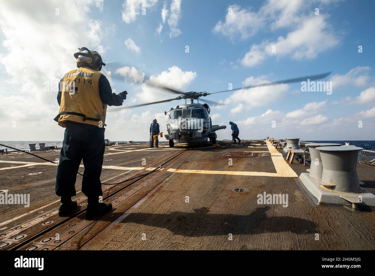 SÜDCHINESISCHES MEER (JAN 19, 2022) Mate Seaman Esau Arellano von Bootsmann aus Fresno, Kalifornien, sendet während des Flugbetriebs an Bord des Lenkflugzeugzerstörers USS Ralph Johnson (DDG 114) Signale an die Piloten eines MH-60R-Hubschraubers. Ralph Johnson ist der Task Force 71/Destroyer Squadron (DESRON) 15 zugeordnet, dem größten vorwärtseingesetzten DESRON der Marine und der wichtigsten Surface Force der US 7th-Flotte. (USA Navy Foto von Mass Communication Specialist 2nd Class Samantha Oblander) Stockfoto