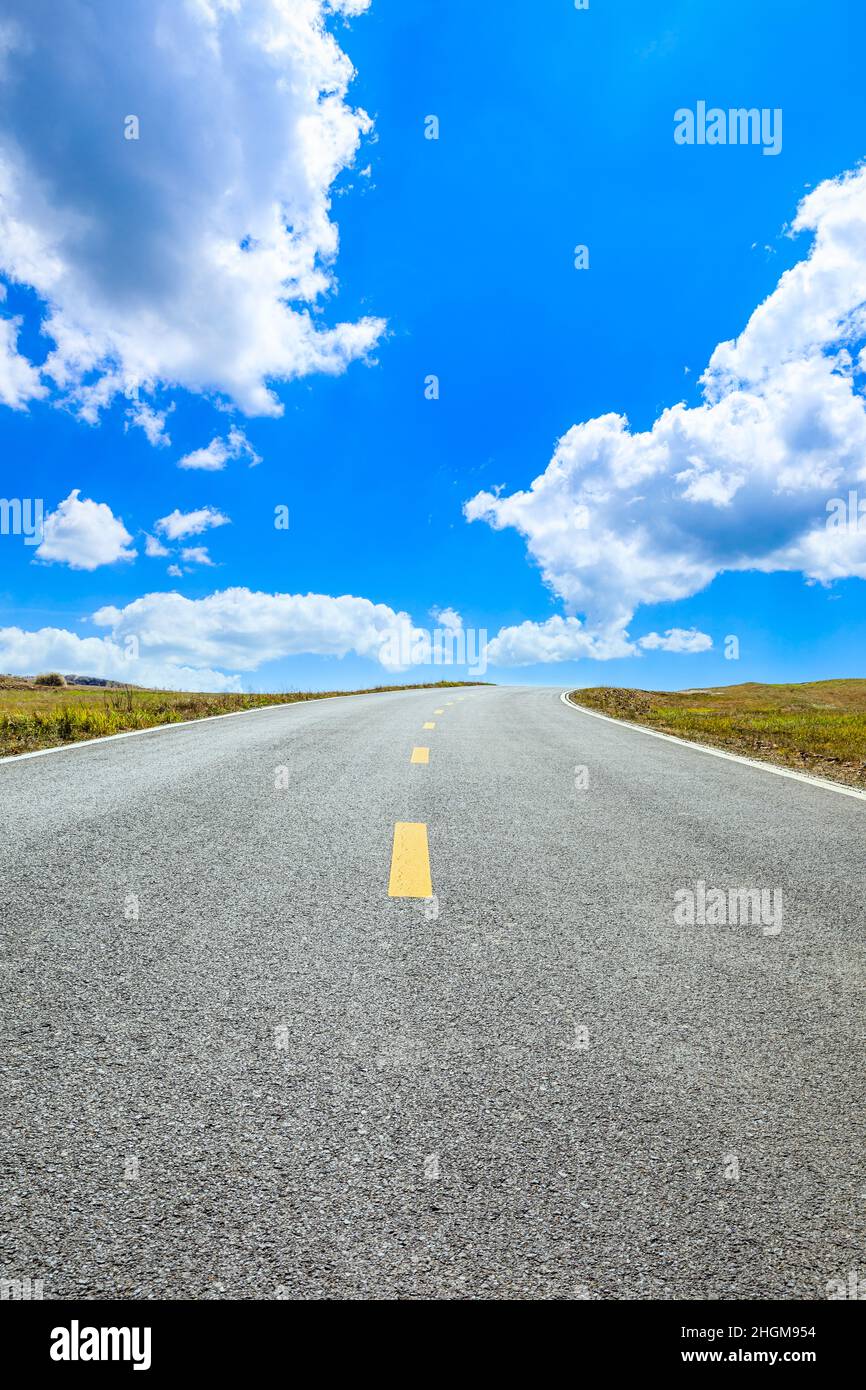 Leere Asphaltstraße und Berglandschaft unter blauem Himmel. Stockfoto