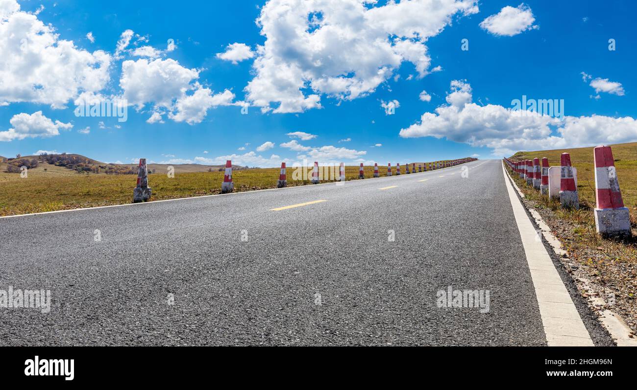 Leere Asphaltstraße und Berglandschaft unter blauem Himmel. Stockfoto