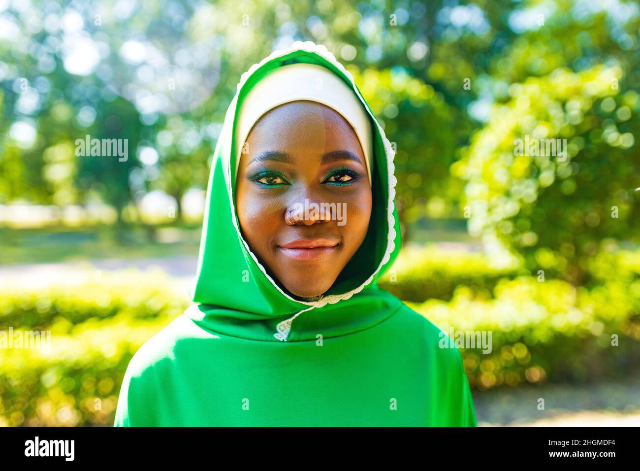 Schöne moderne Studentin in Hijab mit Make-up und Piercing Ring auf der Nase draußen Stockfoto