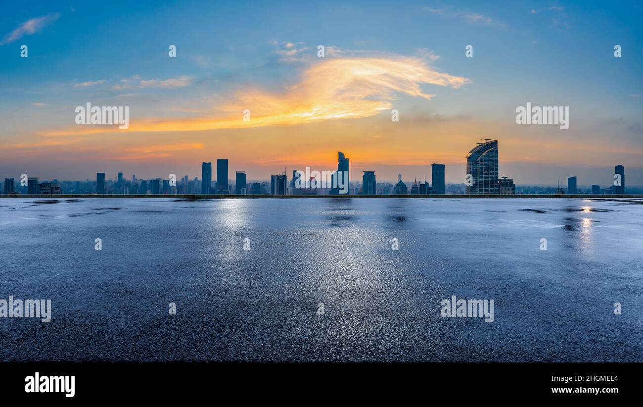 Panorama-Skyline und moderne Geschäftsgebäude mit leerer Straße. Asphaltstraße und Stadtbild bei Nacht. Stockfoto