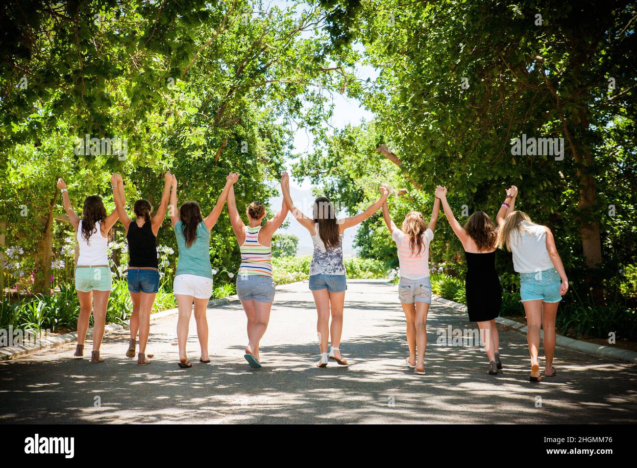 Eine Gruppe von Teenagern, die einen Geburtstag feiern. Freunde halten die Hände Stockfoto
