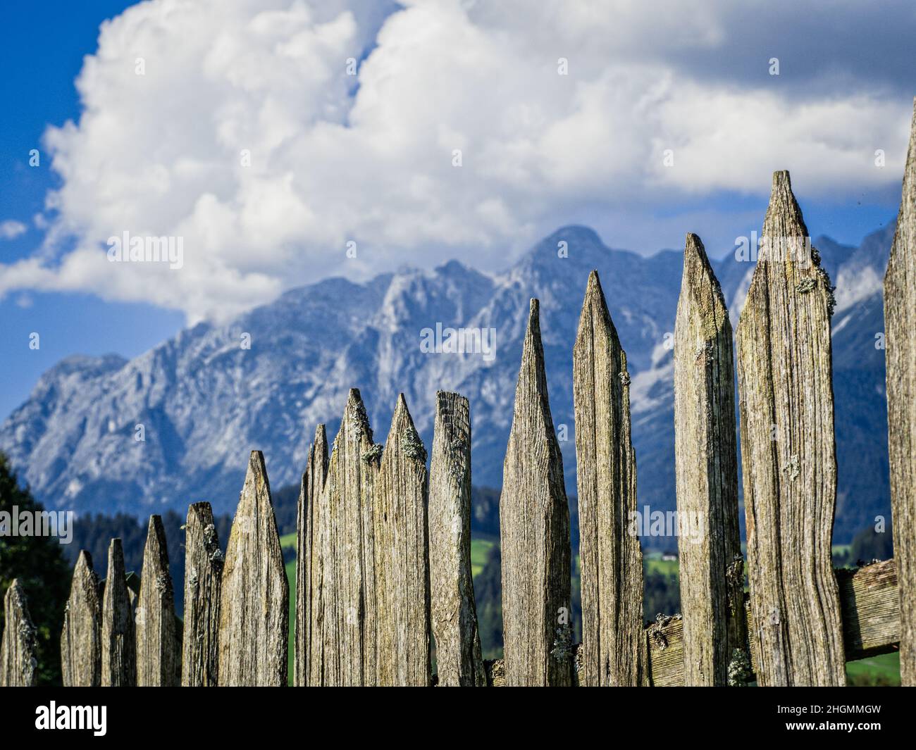 Ein alter Zaun aus Holzlatten vor einem imposanten Bergpanorama. Stockfoto
