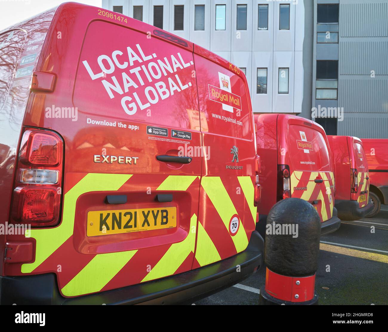 Linie der geparkten Royal Mail roten und gelben Lieferwagen, Kettering, England. Stockfoto