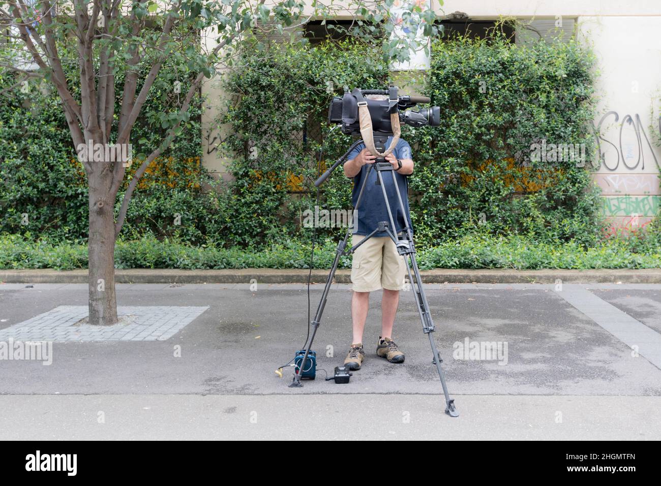 Ein Fernsehkameramann stellt seine Kamera in Sendequalität auf einem Stativ an der Goods Line in Sydney, Australien, auf Stockfoto
