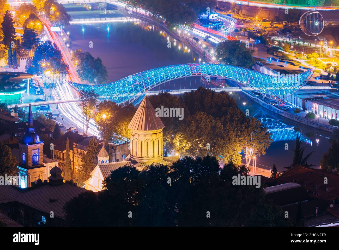 Tiflis, Georgien. Abendnacht Szenischer Luftblick Auf Die Brücke Des Friedens Und Die Kathedrale Von Tbilisi Sioni. Kathedrale Der Heiligen Maria Von Zion. Straßennacht Stockfoto