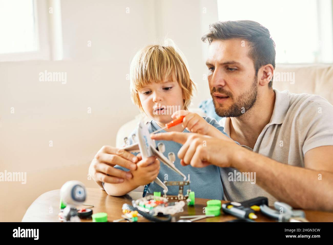 Vater Kind Sohn Familie Mann Junge zusammen Eltern Handwerk Hobby Werkzeug Werkstatt Arbeit handgemacht lernen Unterricht kreatives Spielzeug Stockfoto