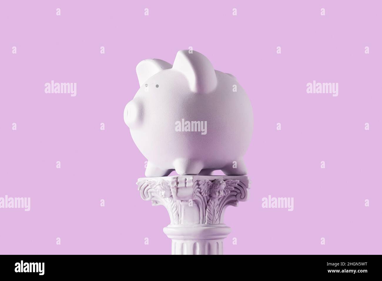 Sparschwein auf antiker Säule. Konzept der Geldeinsparanlagen und Kunst. Stockfoto