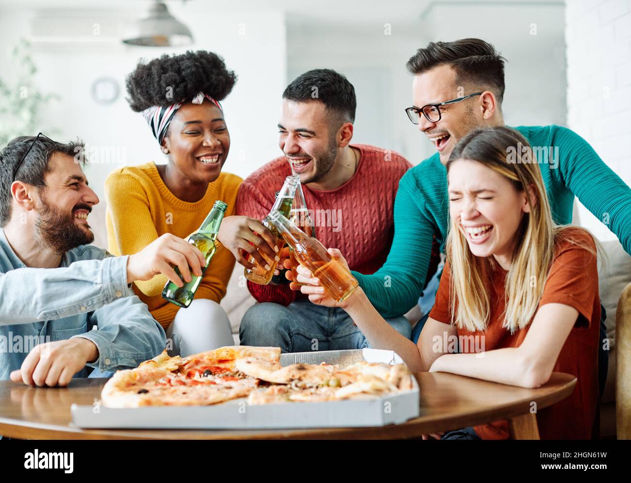 Party Pizza Bier junge Leute Freunde Spaß haben Stockfoto