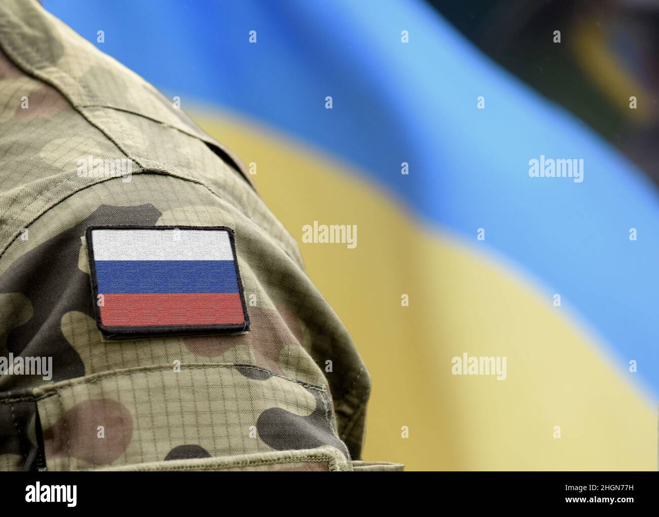 Flagge Russlands auf Militäruniform und Flagge der Ukraine im Hintergrund. Russland gegen die Ukraine. Stockfoto