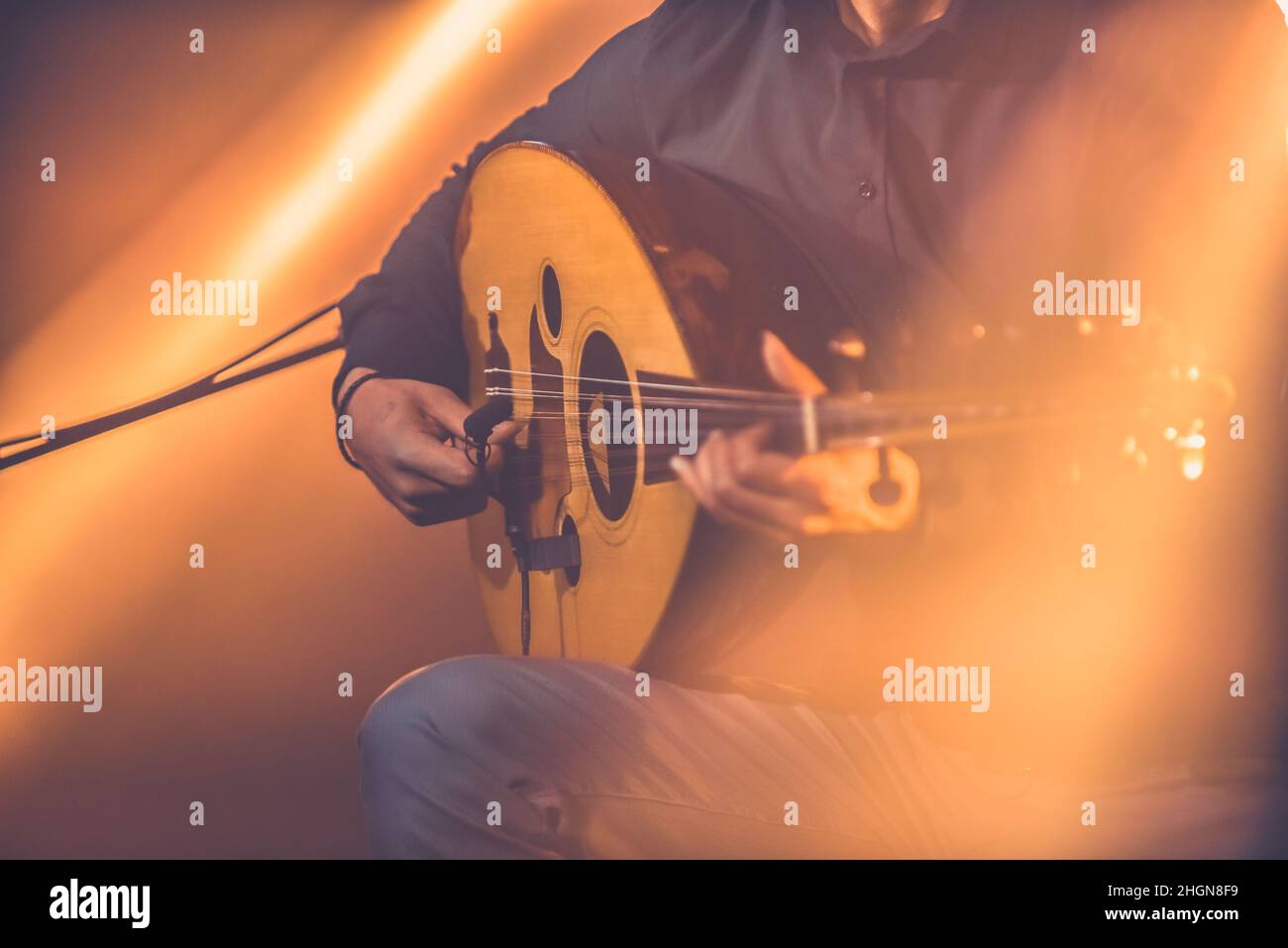 Getöntes Bild eines Musikers, der während des Konzerts traditionelle türkische Oud spielt Stockfoto