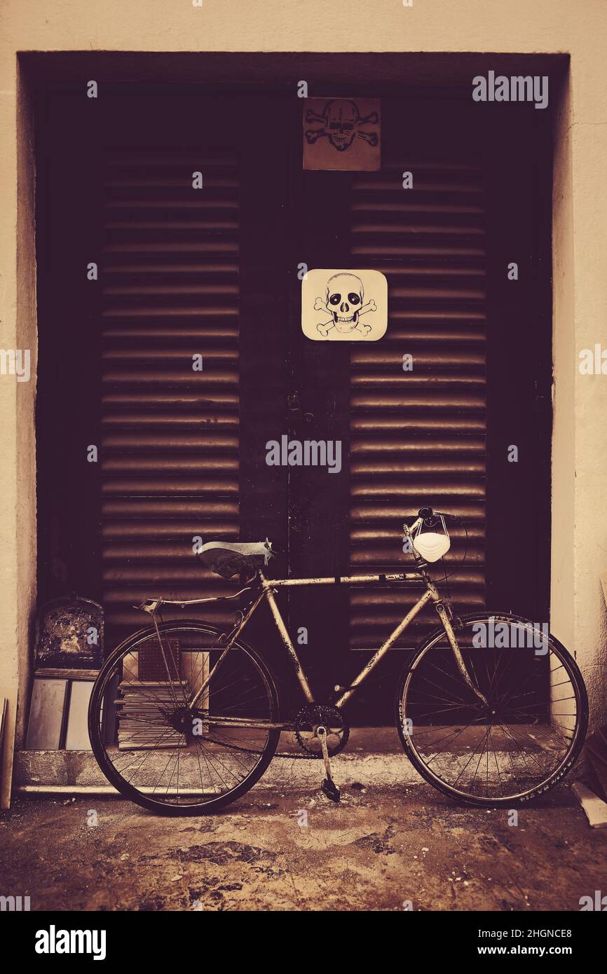 Warnschild an der Tür einer elektrischen Einrichtung und dem benachbarten geparkten Fahrrad. Stockfoto