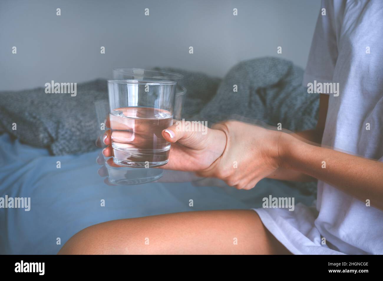 Zittern oder Händeschütteln. Frau mit wackeligen Händen, die an Symptomen der Parkinson-Krankheit oder einem wesentlichen Zittern leidet. Stockfoto