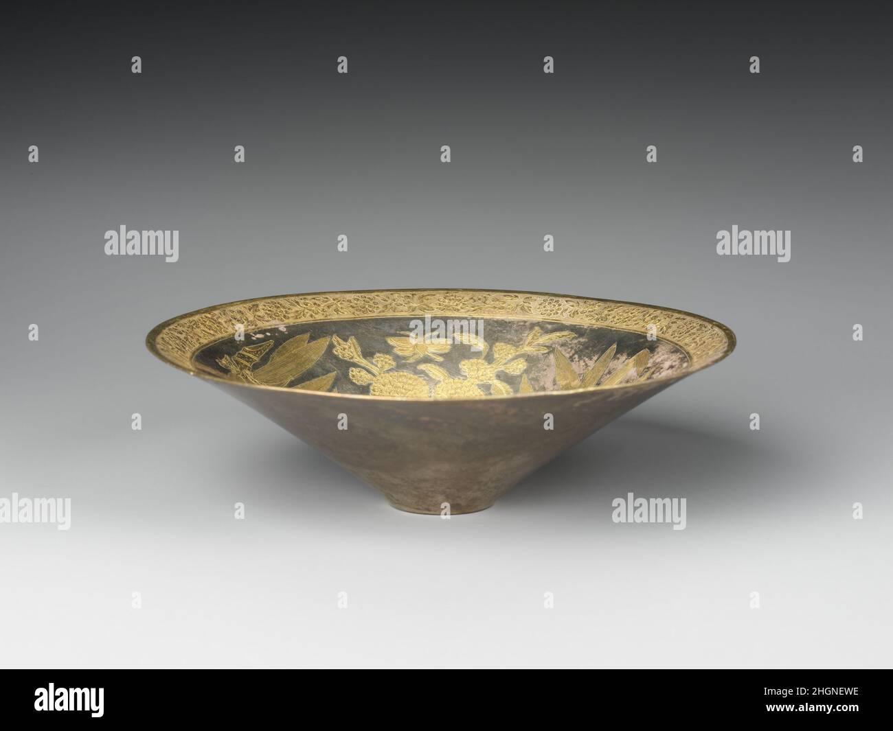 Teeschale China-Gefäße des 13th.–14th. Jahrhunderts wie diese wurden hauptsächlich für formelle Unterhaltung verwendet. Es war wahrscheinlich, dass es in einer der Städte entlang des Unterflusses des Yangzi-Flusses gemacht wurde. Das Gefäß hat die gleiche Form wie zeitgenössische Werke aus Porzellan und Lack. Teeschale. China. 13th–14th Jahrhundert. Silber mit verjagter und gestanzter Verzierung und Vergoldung. Südliche Song-Dynastie (1127–1279)–Yuan-Dynastie (1271–1368). Metallverarbeitung Stockfoto