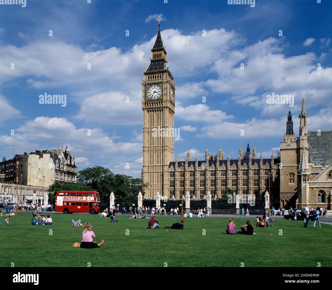 England. London. Houses of Parliament vom Parliament Square mit klassischem roten Routemaster-Doppeldeckerbus. Stockfoto
