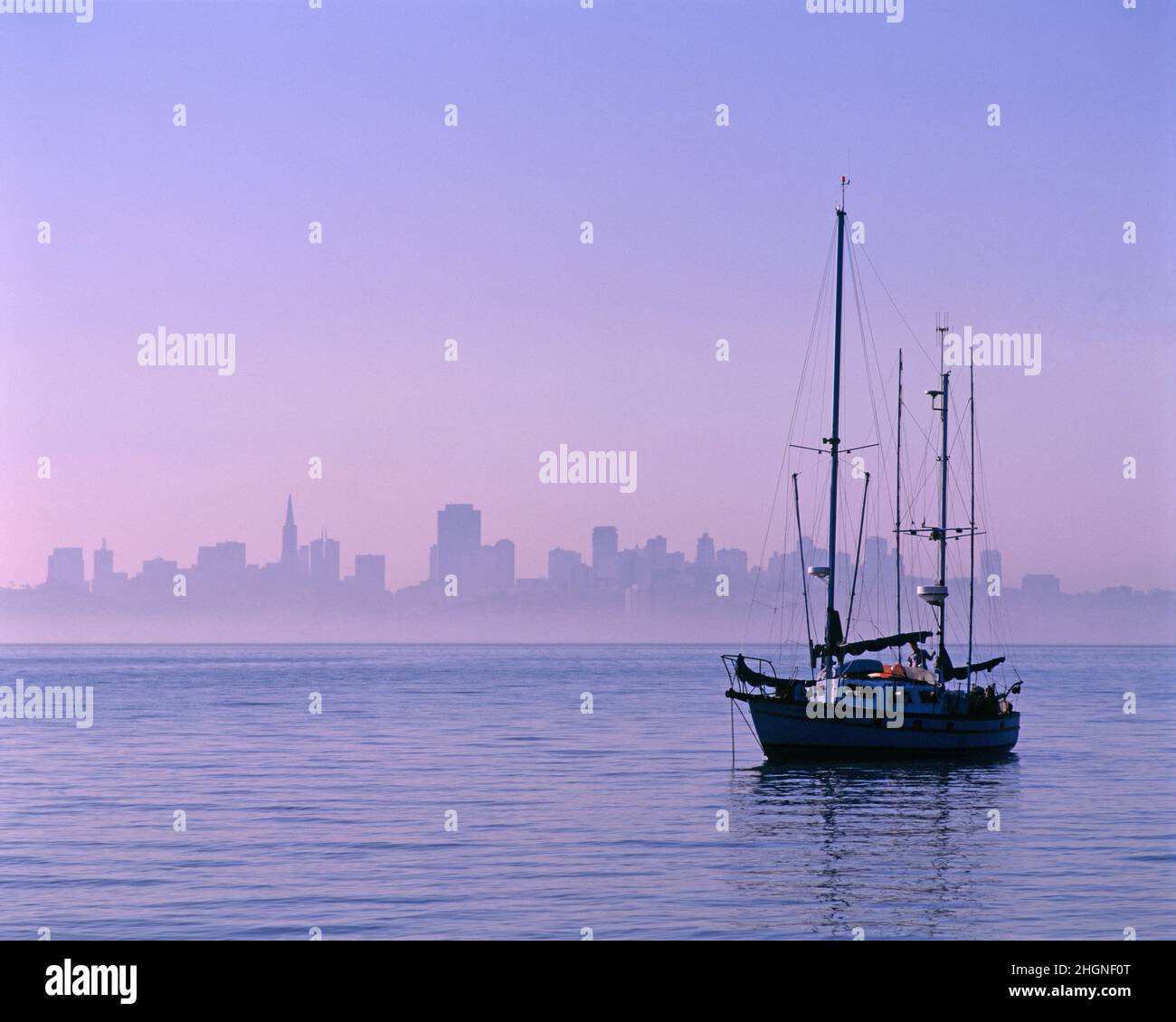 USA. Kalifornien. San Francisco. Skyline der Stadt bei Sonnenaufgang mit Segelboot vor Anker. Stockfoto