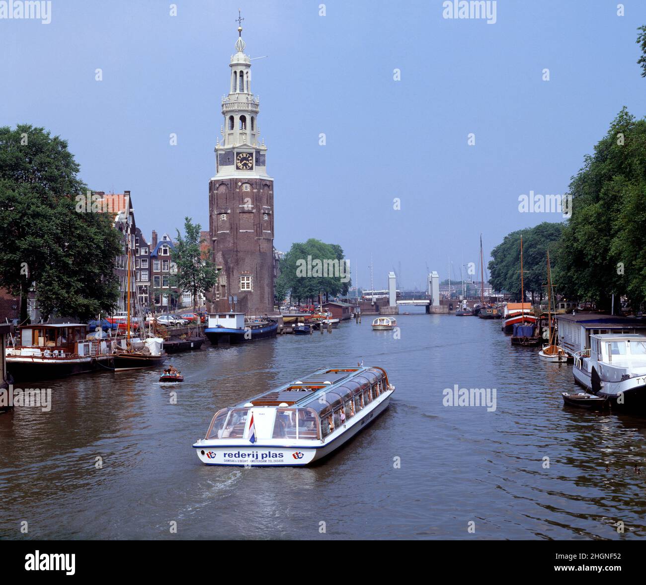 Niederlande. Amsterdam. Montelbaan Tower. Boote auf dem Oudeschans-Kanal. Stockfoto