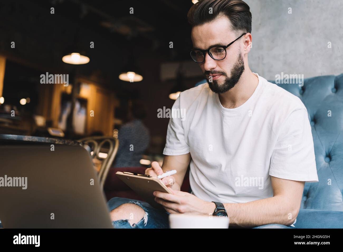 Qualifizierter Mann sucht informative Publikation während der Ausbildung Studium über Netbook Stockfoto