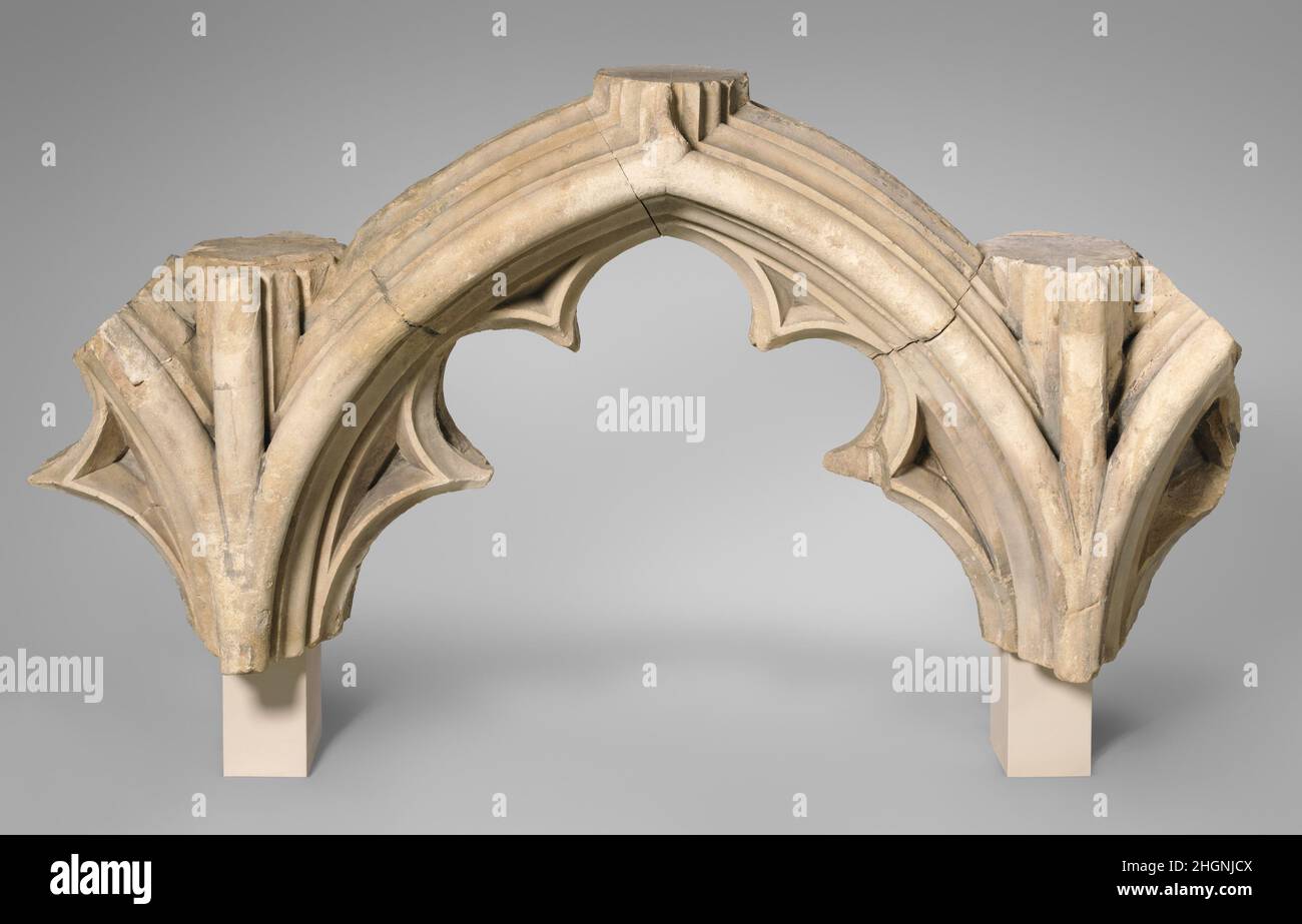Tracery Arcade vom Großen Südfenster der Kathedrale von Canterbury Ca. 1426–1435 Entwurf vielleicht von Meister Freimaurer Stephen Lote Diese Fragmente umrissen einst eine Glasmalerei im "Großen Südfenster" des Südtransepts der Kathedrale von Canterbury. Im Einklang mit der mittelalterlichen Praxis wurden die beiden Seiten des Bogens in verschiedenen, wenn auch komplementären Weisen geschnitzt. Die zum Inneren der Kirche gerichtete Seite besteht aus drei wellenförmigen Gängen. Das Äußere, das den Stress und die Reparaturen aufweist, die von jahrhundertelangen Belastungen durch die Elemente erwartet werden, zeigt eine einfachere facettierte Formgebung. Stockfoto