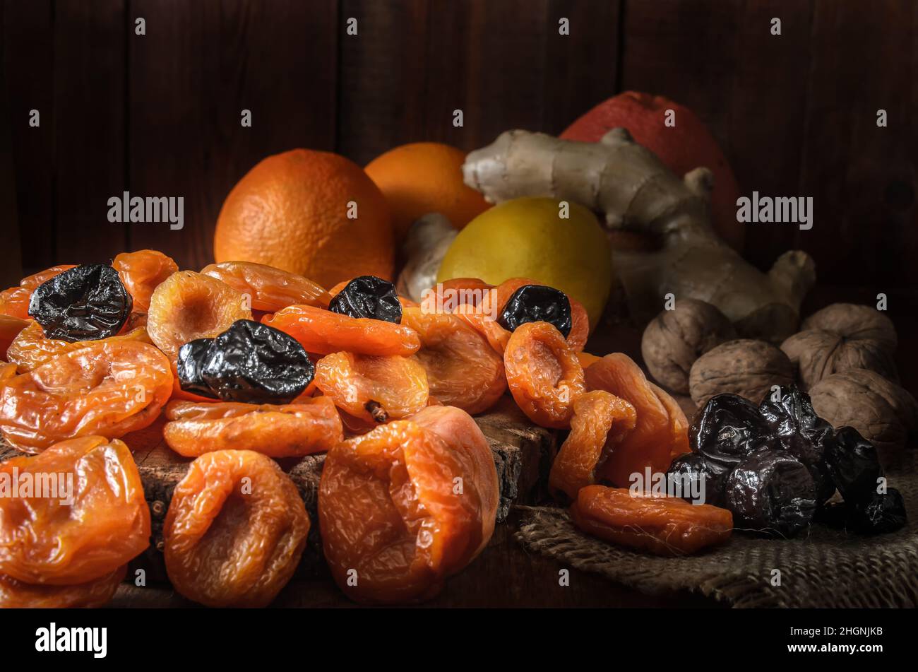 Getrocknete Aprikosen und andere getrocknete Früchte auf dunklem Holzgrund Stockfoto