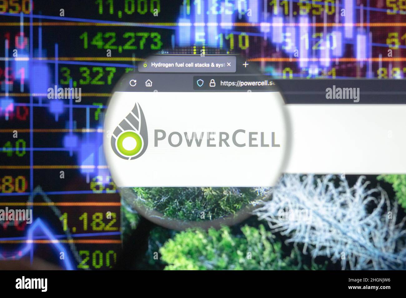 POWERCELL Firmenlogo auf einer Website mit verschwommenen Börsenentwicklungen im Hintergrund, die auf einem Computerbildschirm durch eine Lupe gesehen werden. Stockfoto