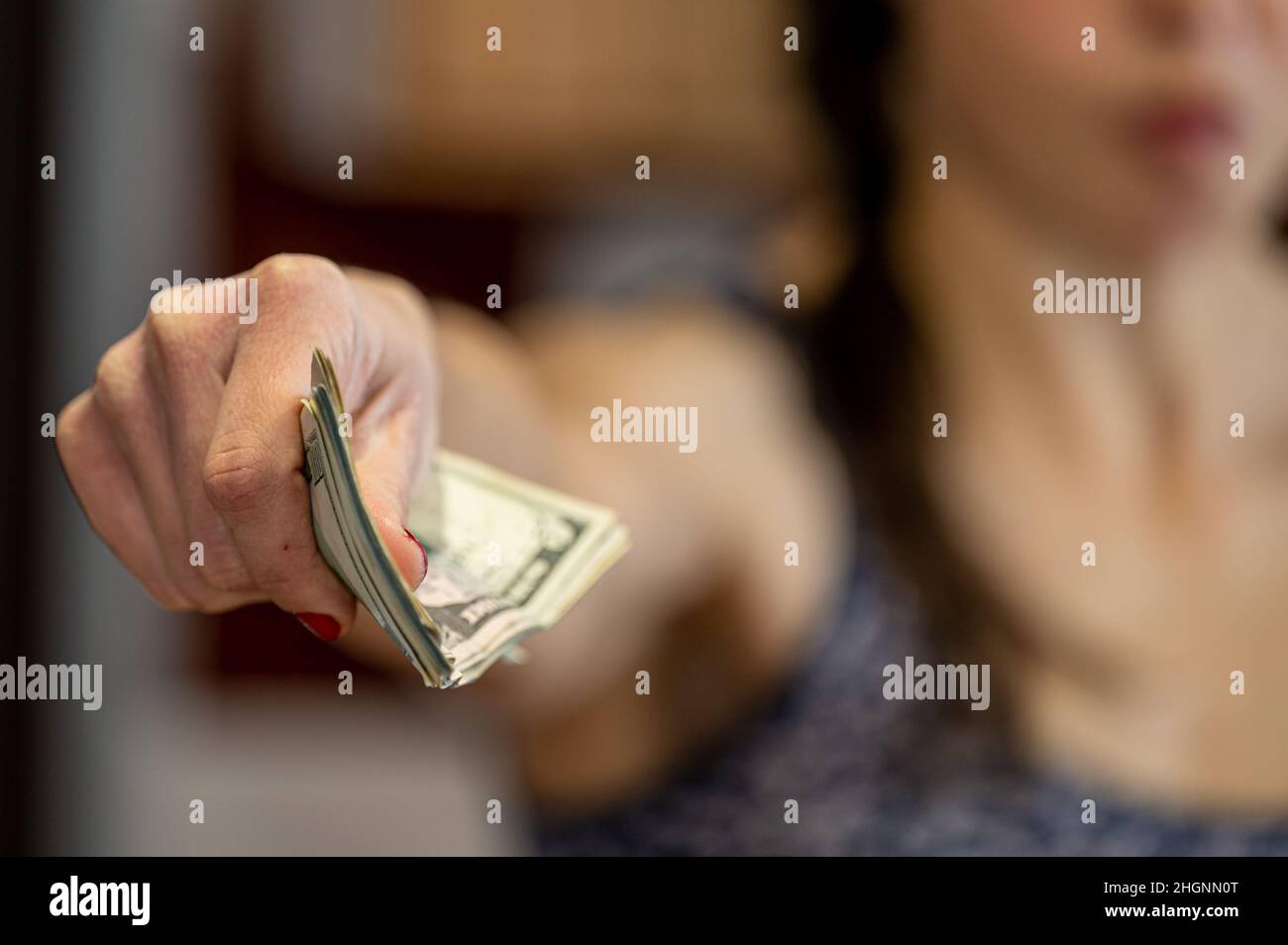 Nahaufnahme einer Frau, die Geld gab. Stockfoto