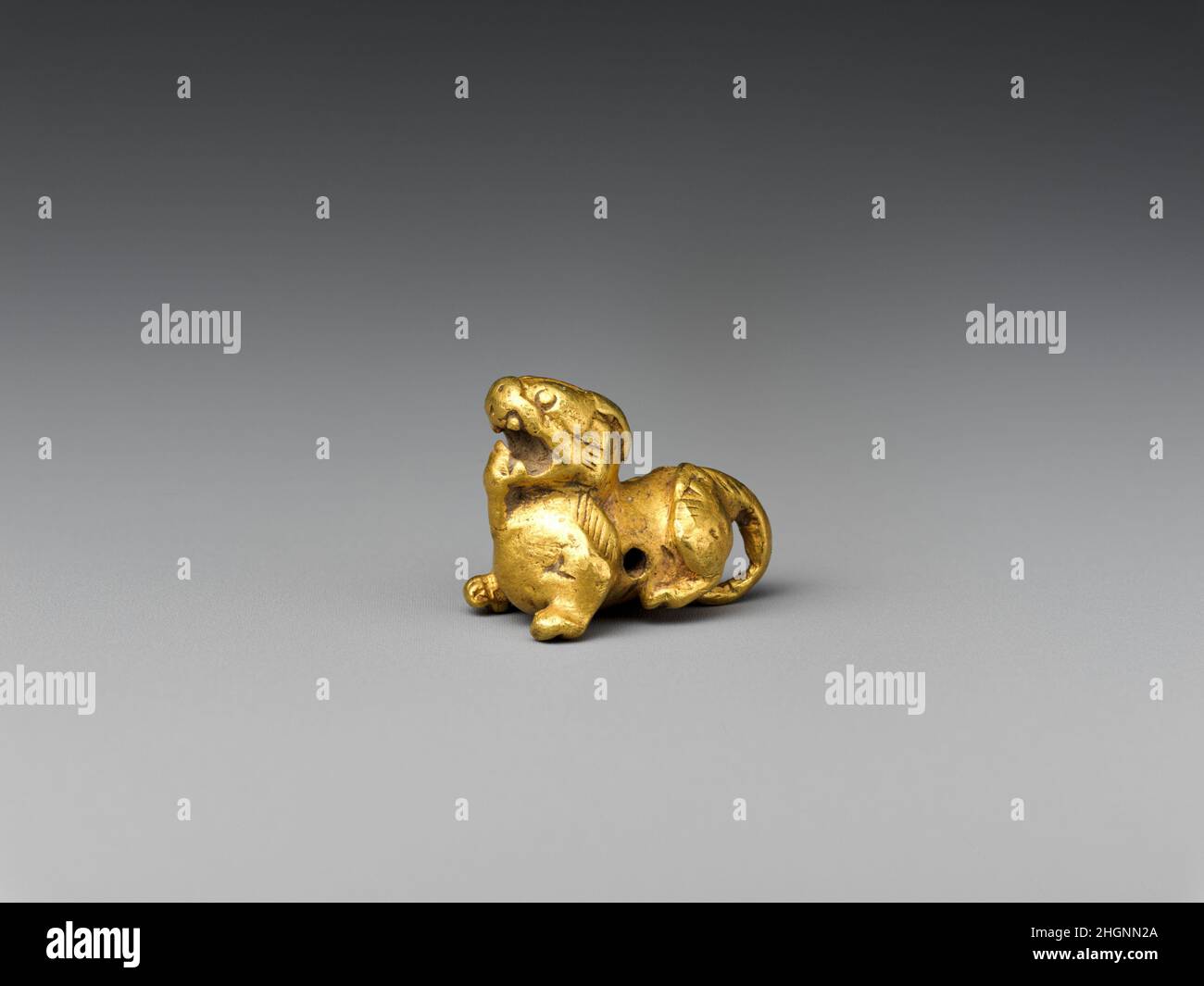 Chimera (Bixie) (a); Lupe (b) 1st Jahrhundert (a); 20th Jahrhundert (b) China. Chimera (Bixie) (a); Lupe (b). China. 1st Jahrhundert (a); 20th Jahrhundert (b). Gold (a); Glas, Schildkrötengehäuse (b). Han-Dynastie (206 v. Chr.–n. Chr. L 220, S. Skulptur Stockfoto