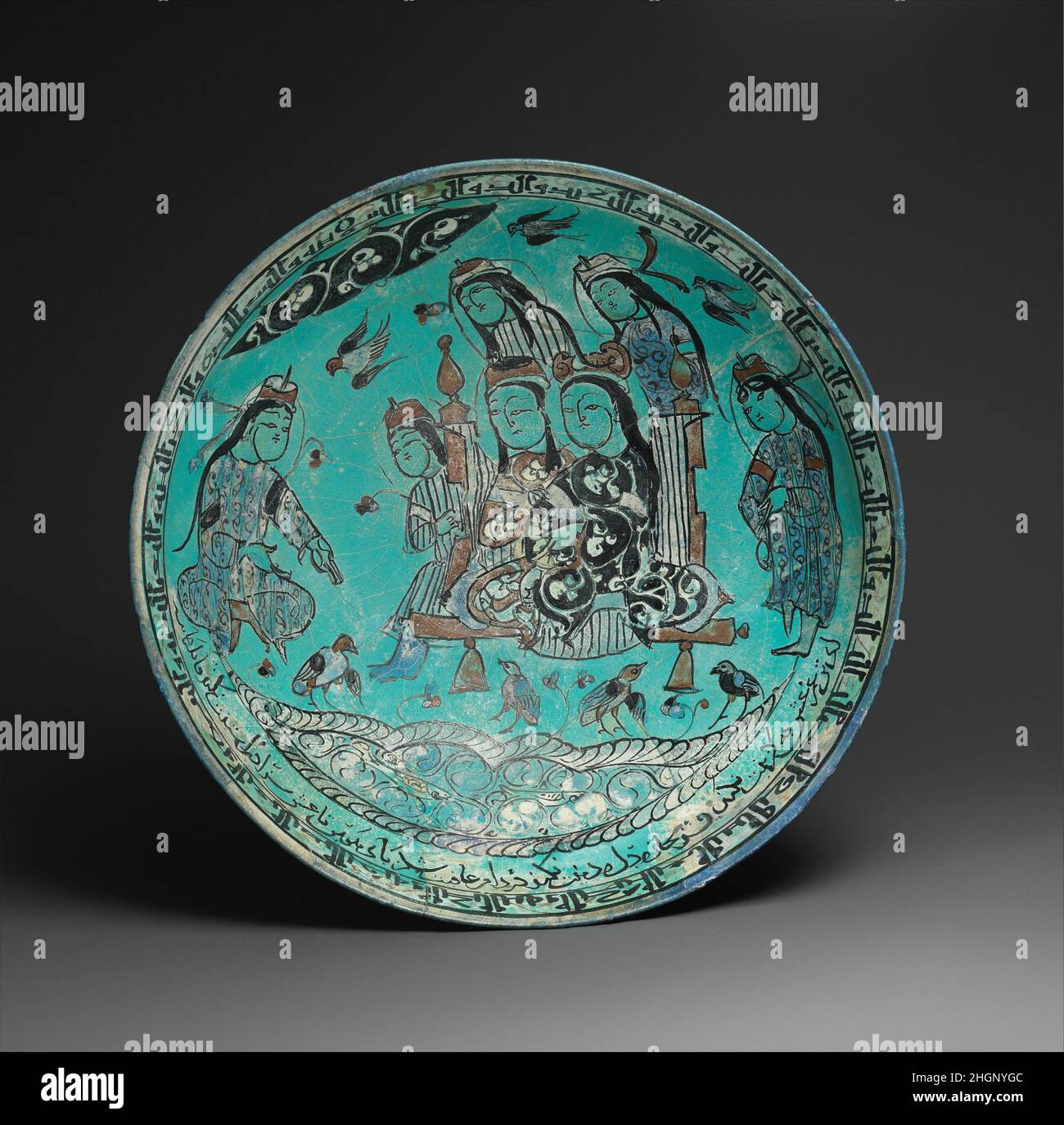 Schüssel mit einer Majlis-Szene durch einen Teich datiert A.H. 582/ A.D. 1186 Abu Zayd al-Kashani während der fast vierzig Jahre, die er als Meistertopferer tätig war, war Abu Zayd auch ein kompetenter Dichter. Er komponierte mindestens eines der Liebesgedichte, die auf dieser Schale eingeschrieben waren. Die abgebildete Szene, wahrscheinlich ein literarischer majlis, bezieht sich nicht explizit auf eines dieser Gedichte. Der Darsteller links kann jedoch so interpretiert werden, dass er sie den Figuren rezitiert, die auf und um die erhöhte Plattform sitzen. Oh Geliebte, habt ihr gesehen, was der Schnee (weiße Haare) mit mir gemacht hat? / Oh Schnee (weiße Haare), hast du mir gesagt, aber sag es meinem Geliebten // zu Stockfoto