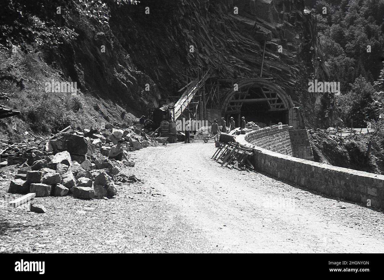 1950s, historisch, Sommerzeit und Arbeiter auf einer Bergstraße, die Bauarbeiten oder Reparaturen an einem Tunnel durchführen, Pryenees, Südfrankreich. Stockfoto