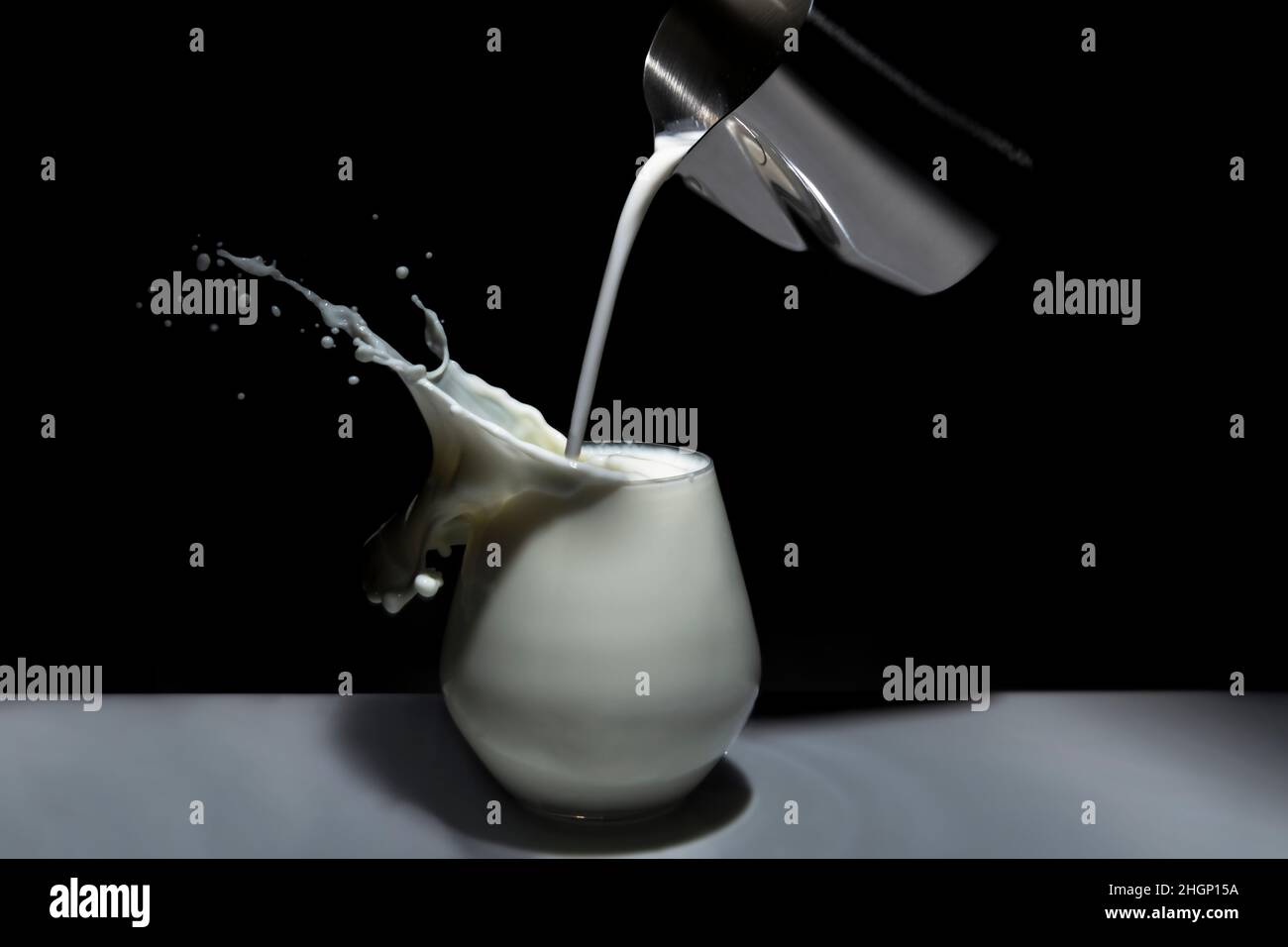 Krug, der Milch in ein Glas gießt. Selektiver Fokus Stockfoto