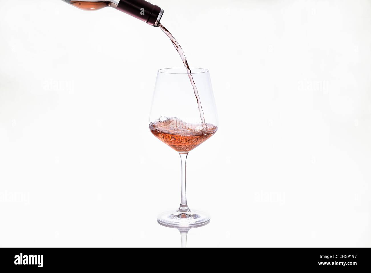 Glas, das Wein aus einer Flasche serviert Stockfoto