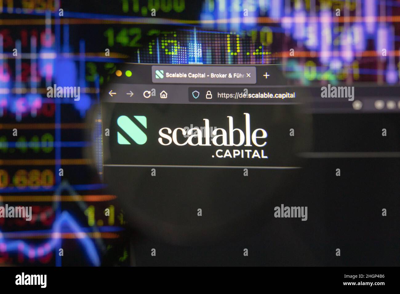 Scalable Capital Firmenlogo auf einer Website mit verschwommenen Börsenentwicklungen im Hintergrund, auf einem Computerbildschirm gesehen. Stockfoto
