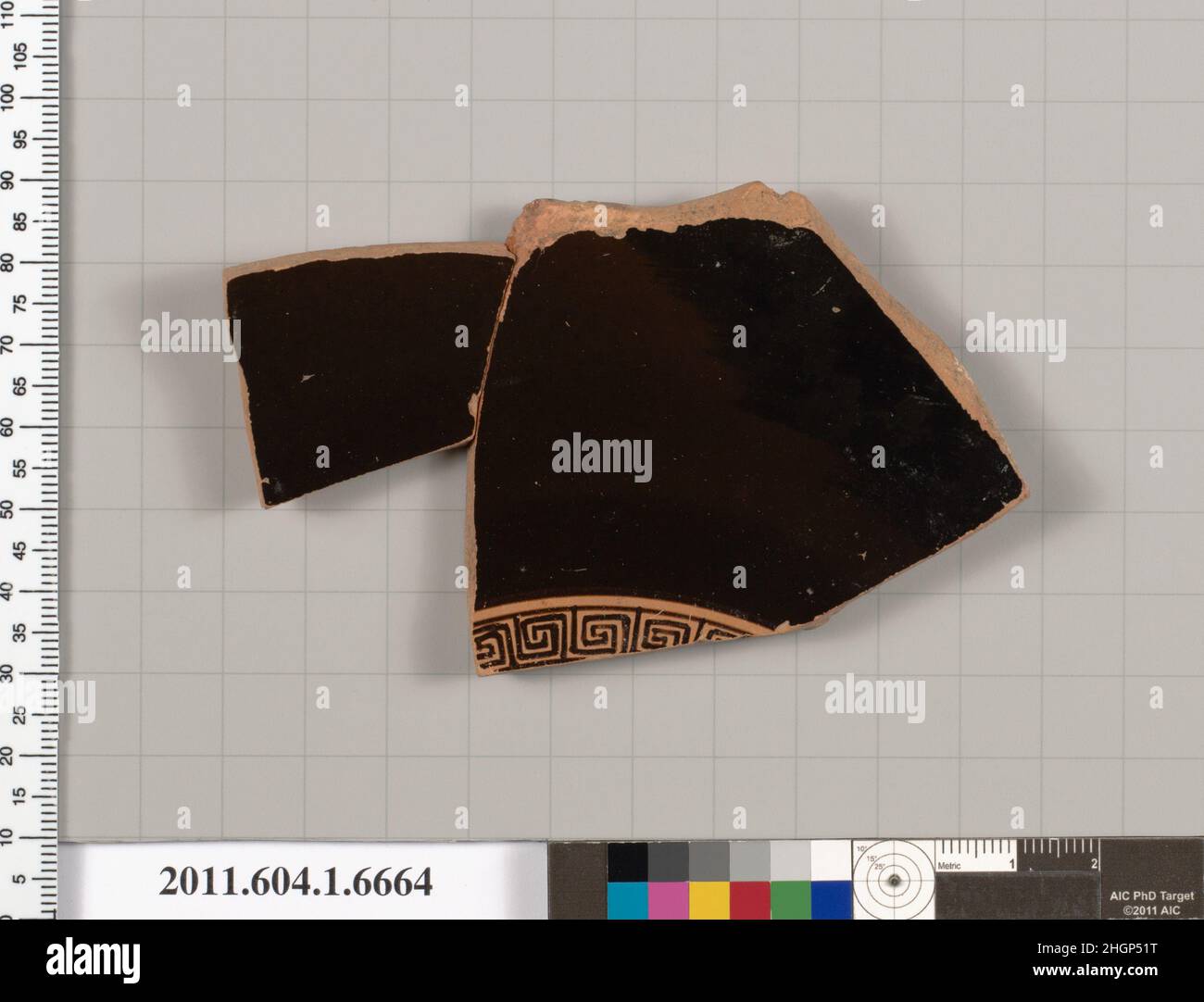 Terrakotta-Fragment einer Kylix (Trinkbecher) 490–470 v. Chr. Griechisch, attischer Innenraum, Mäander; Außenseite, knobby Stock; Jugend, in Dreiviertelansicht, mit Himation drapiert über seinen ausgestreckten linken Arm; unterer Rücken, Gesäß, Oberschenkel und rechter Ellbogen eines drapierten Mannes mit Stockfüßen. Terrakotta-Fragment einer Kylix (Trinkbecher) 709834 Stockfoto