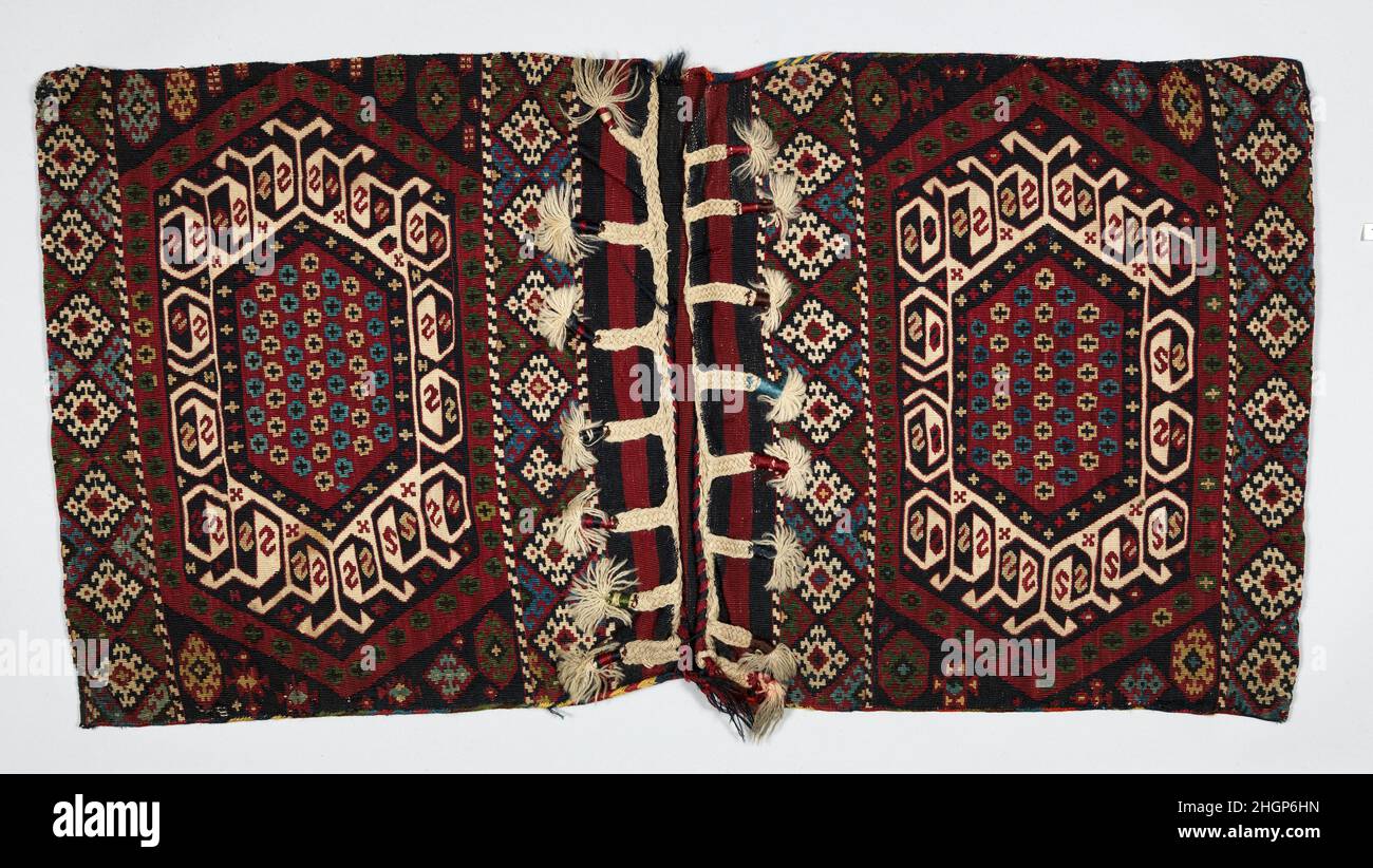 Double Saddlebag (Heybe) ca. 1880 Diese Tasche verfügt über die Spaltteppich-Technik (auch Kilim genannt). Seine Metallfäden verleihen dem Hotel einen Hauch von Luxus und sollten böse Geister abwehren. Der Streifen aus reinem Kupfer ist auf einer Seite mit Messing beschichtet, um Gold zu imitieren. Der Verschluss ist mit schrägen Verflechtung und flachen Zöpfen abgeschlossen, die als Schlaufen für den innovativen Verschluss dienen. Die mit der Marktstadt Reyhanl? An der Grenze zwischen der Türkei und Syrien verbundenen Kelim-Textilien wurden von Gruppen hergestellt, die sich zwischen den Weiden des Taurusgebirges und den Mittelmeerküsten bewegten. Doppelter Sattelsack (Heybe) Stockfoto