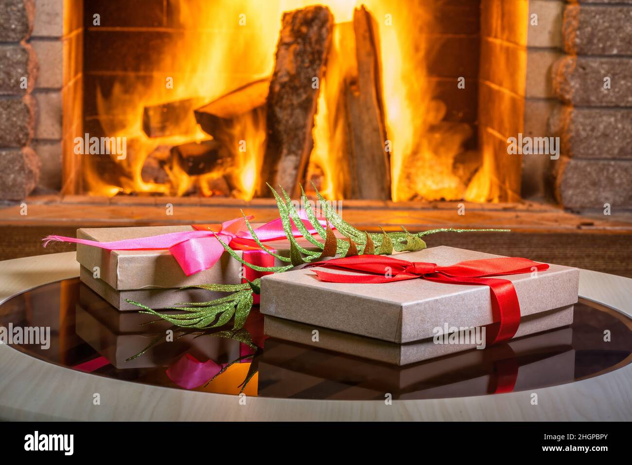 Heiligabend. Geschenkboxen in der Nähe von gemütlichem Kamin, im Landhaus. Stockfoto