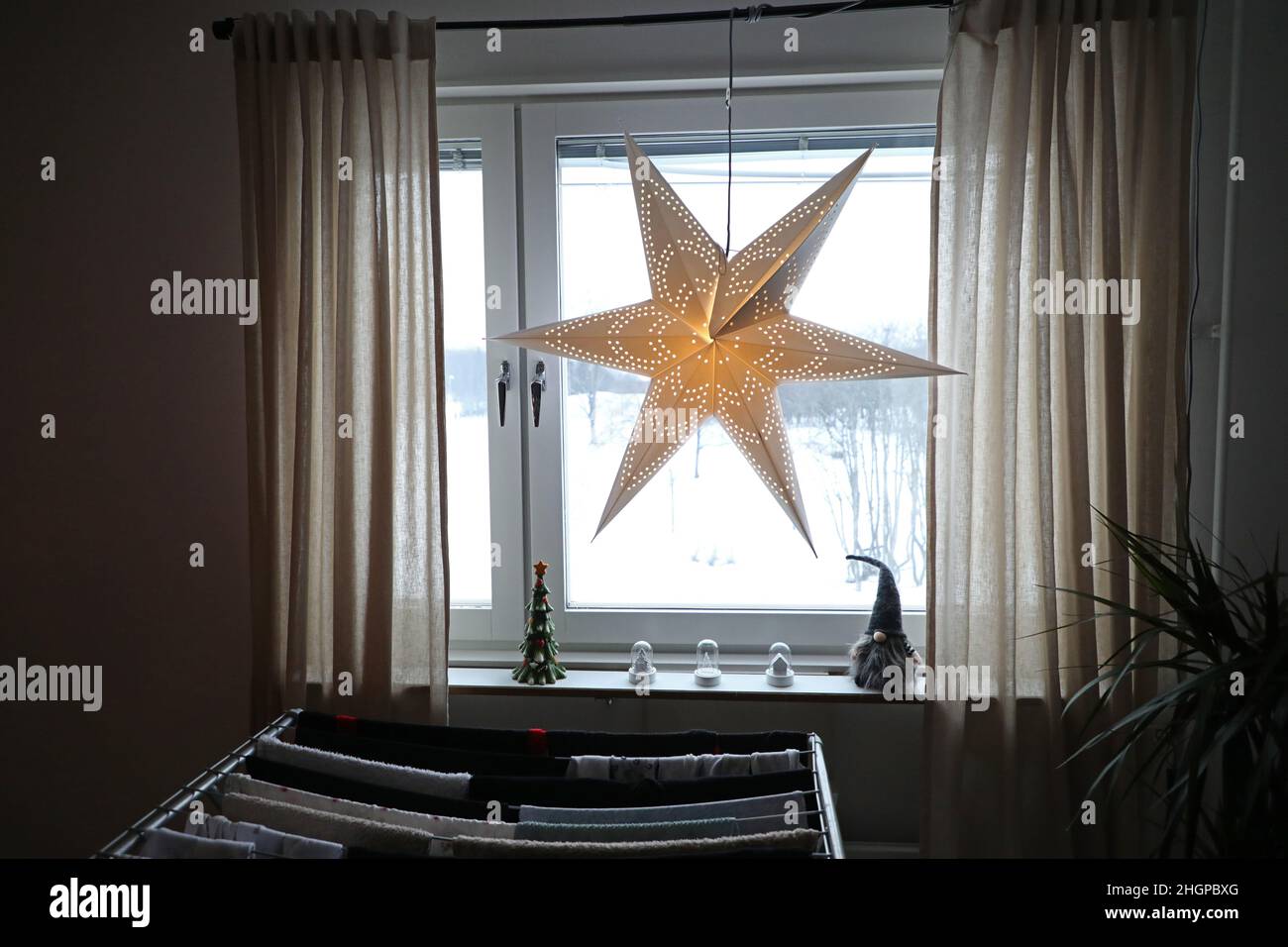 Weihnachtsschmuck in einem Haus am zweiten Adventssonntag. Ein Adventsstern in einem Fenster. Stockfoto