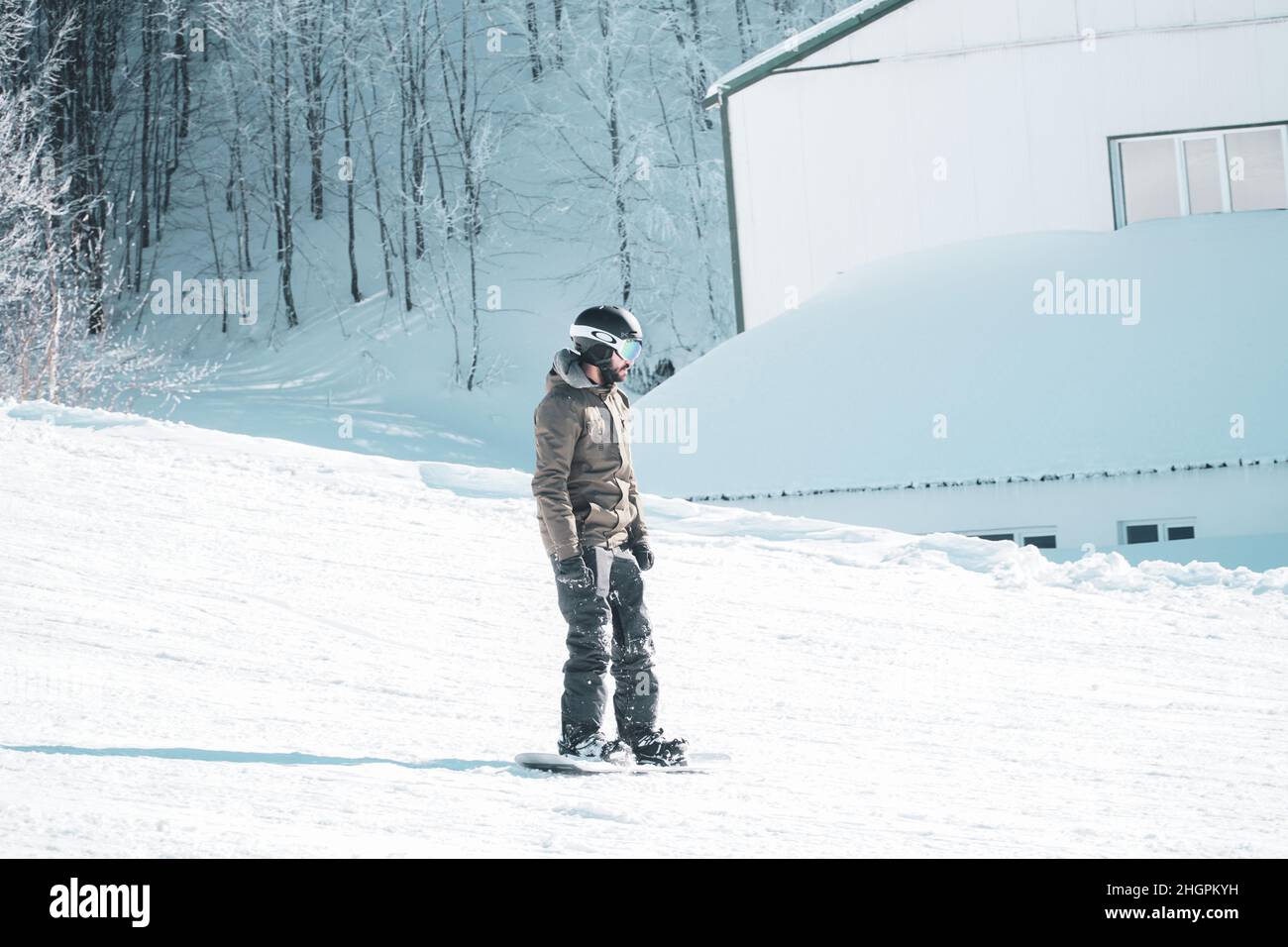 Mann in warmen Kleidern Snowboarding Downhillfreestyle. Wintersportkonzept. Extremsport in der Wintersaison. Snowboarder genießen Extremsport. Stockfoto