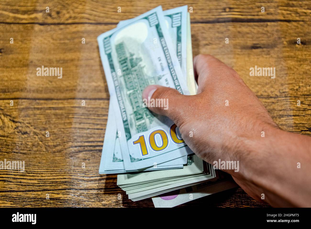 Der Mann am Tisch hält Rechnungen. Dollar in der Hand. Stockfoto