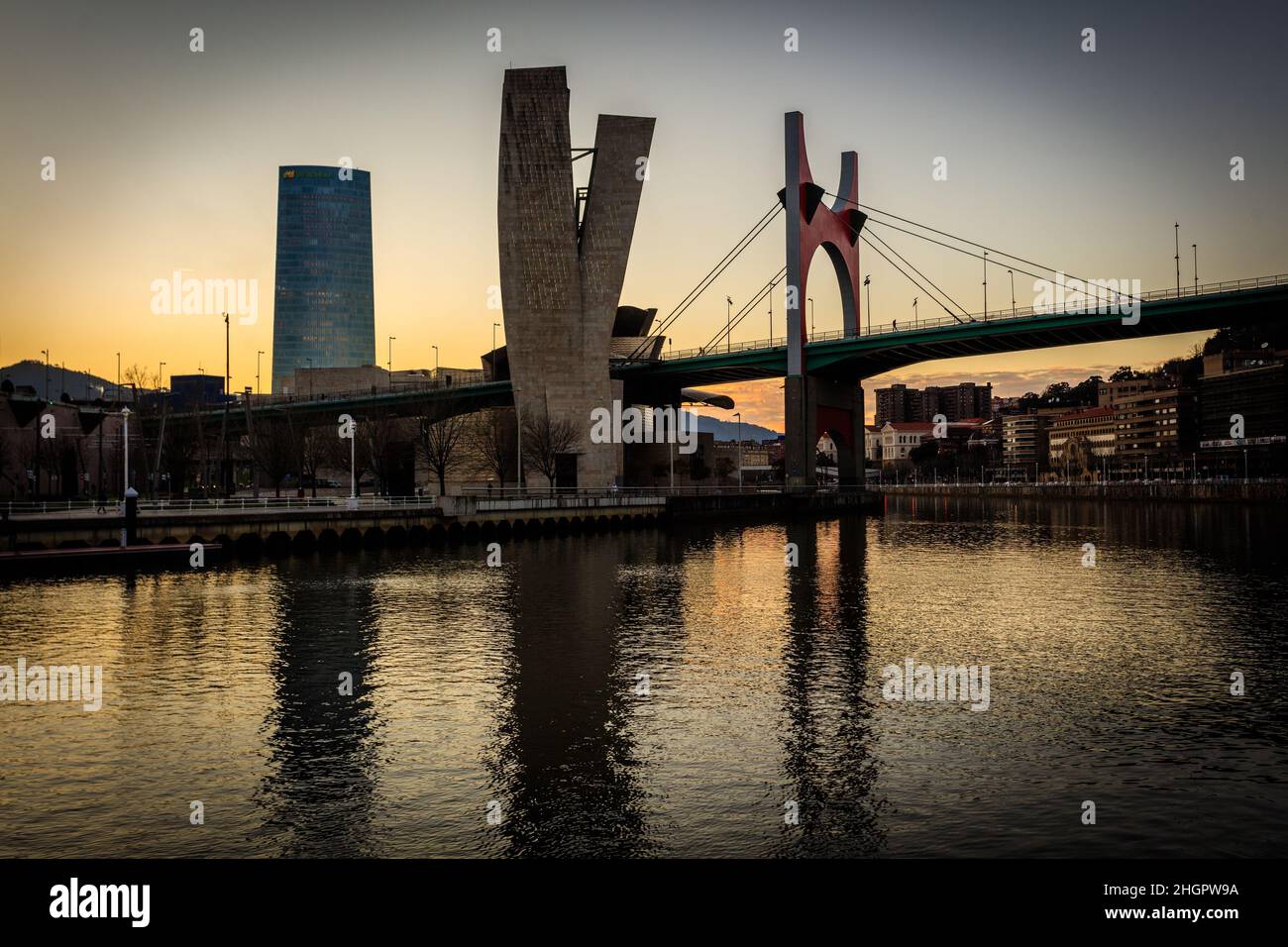 Panoramablick auf die Brücke La Salve bei Sonnenuntergang über der Bilbao Ria, dem Iberdrola-Turm und dem Guggenheim Museum für zeitgenössische Kunst. Spanien. Stockfoto