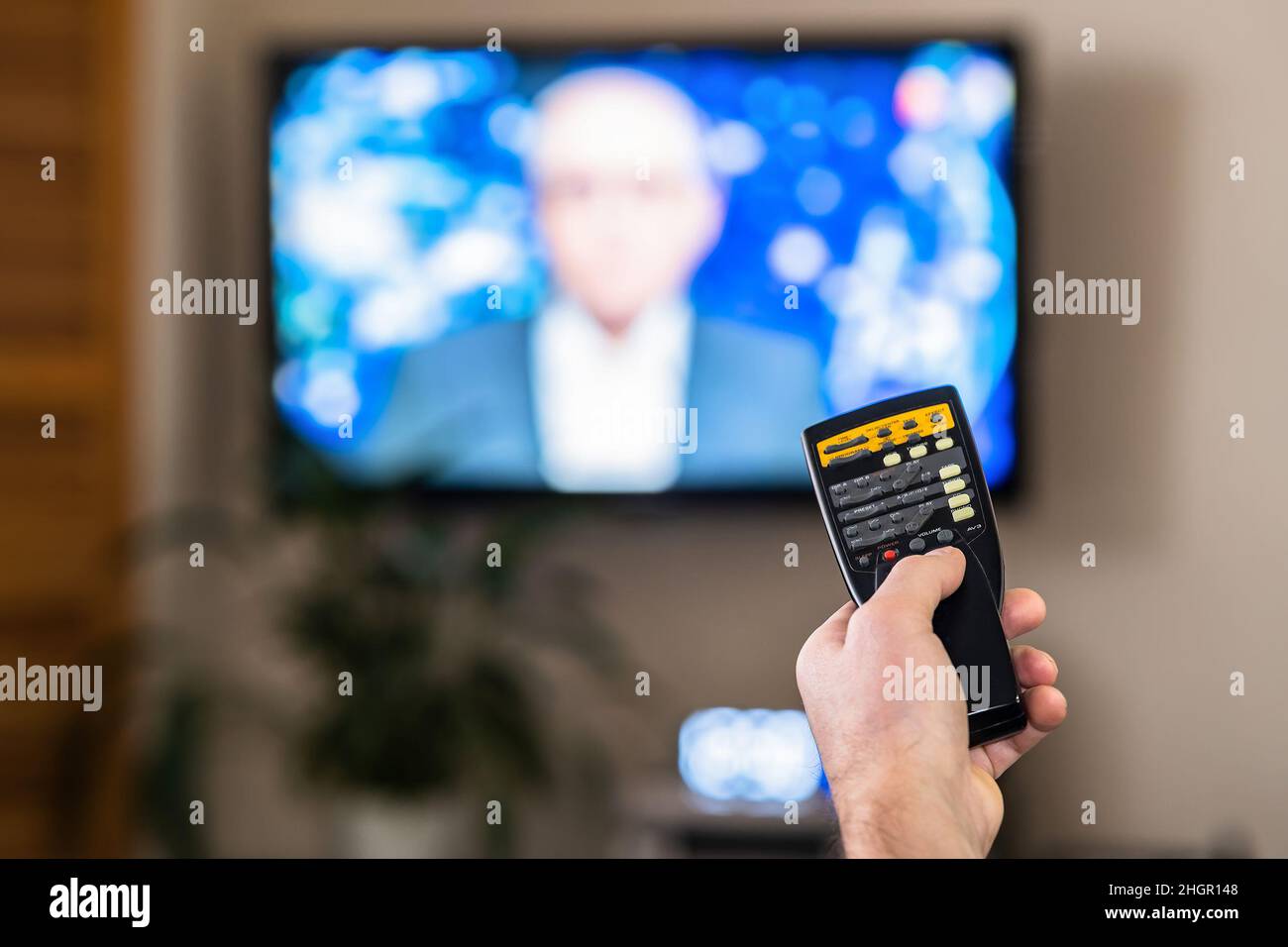 Eine Hand mit einer TV-Fernbedienung. Das Konzept der Fernkommunikation. Symbole der Wiedergabetaste. Steuerung des Media-Players des Fernsehers Stockfoto