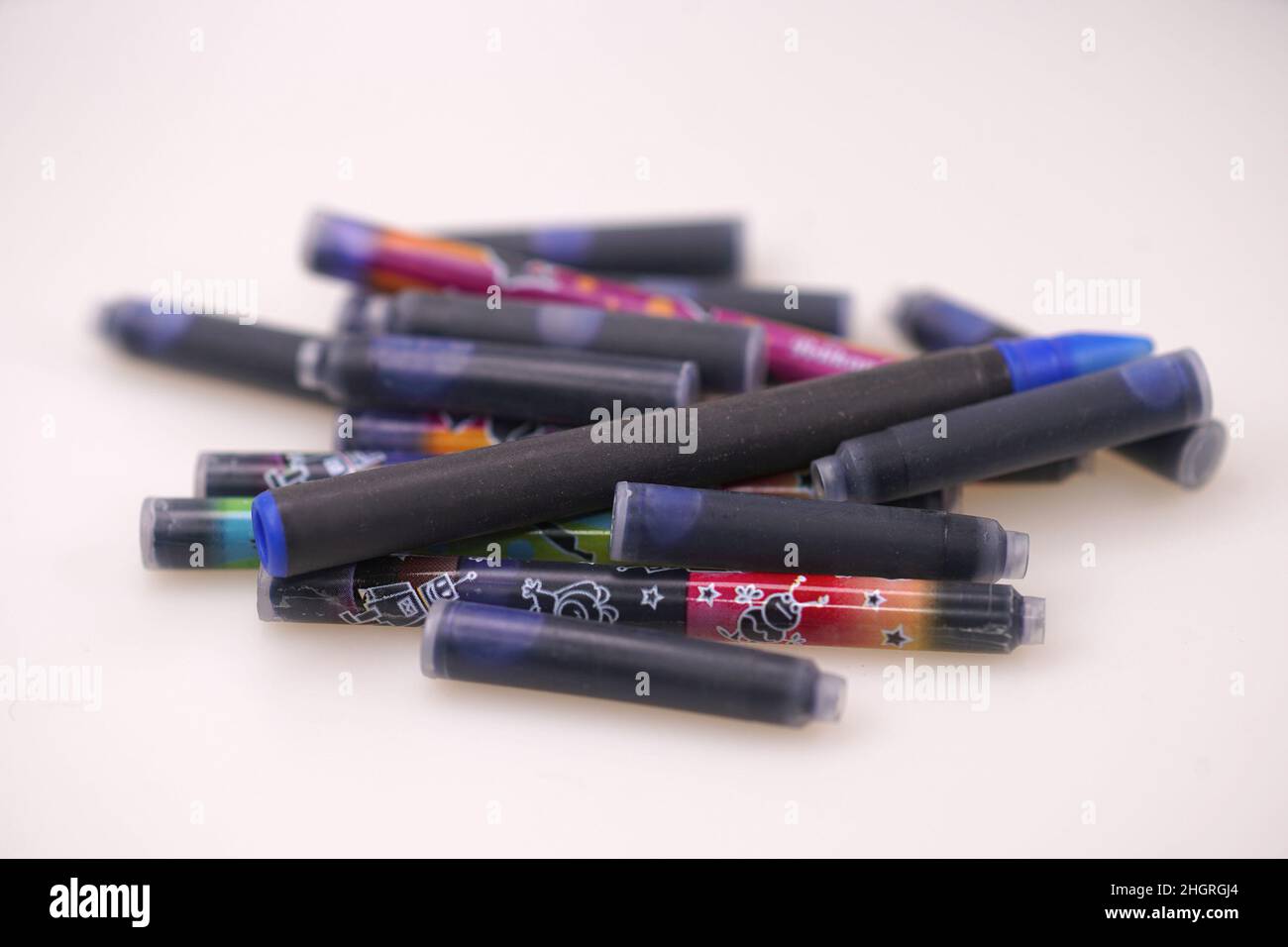 Nahaufnahme eines Stapels verschiedener Farbtintenpatronen für den Stift auf weißem Hintergrund Stockfoto