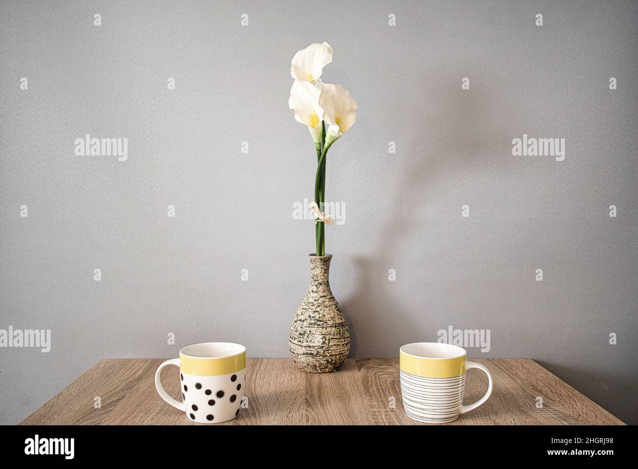 Tisch für zwei Personen mit Blume in einer Vase und zwei Tassen Stockfoto