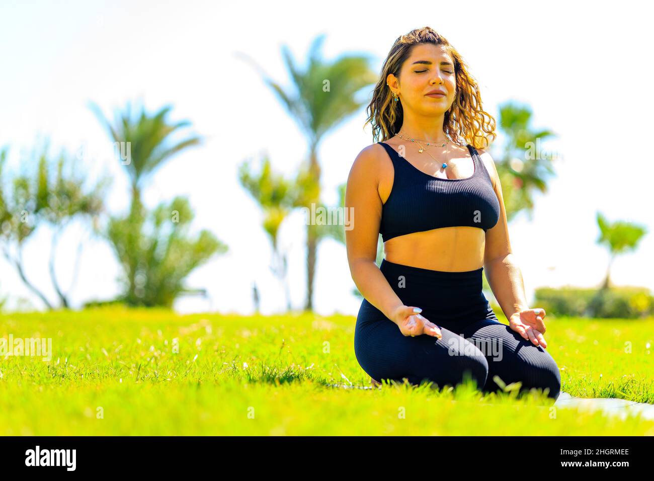 Junge indische attraktive Frau praktiziert Yoga, tief ruhige Atmung im Freien im Sommer grünen Park Stockfoto