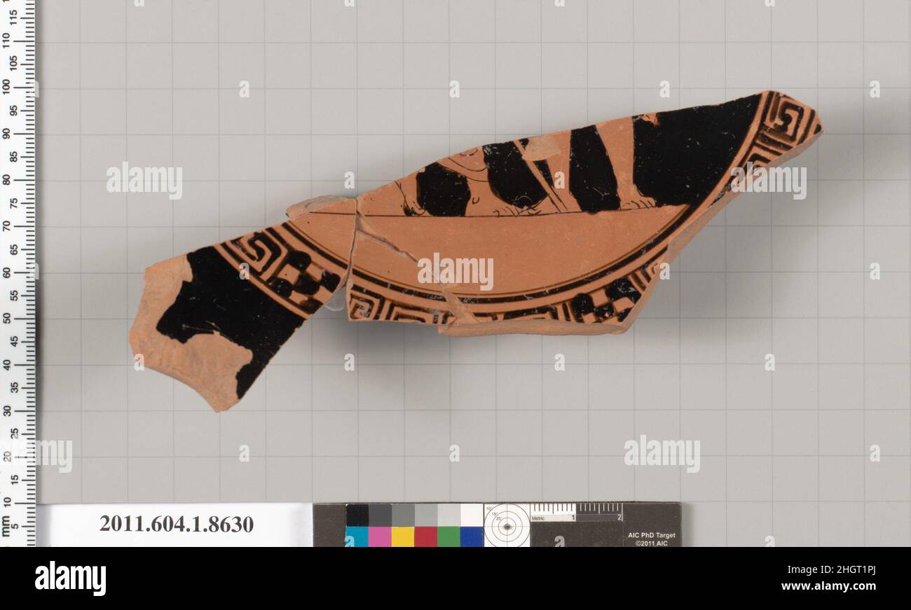 Terracotta-Fragment einer stammlosen Kylix (Trinkbecher) 460–450 v. Chr. Griechisch, Dachboden, auf einem Abschnitt, Füße eines drapierten, rechts sitzenden Männchens, dessen linker Fuß auf einem Felsen ruht und sich auf einen Stab stützt; Kälber und Füße eines Männchens mit Drapierung; Außen, Teil einer umschriebenen Palmette mit Ranken; Beine und Füße eines drapierten Männchens nach rechts, auf einem Stock gelehnt; Füße eines Männchens, mit rechem Fuß im Profil, linker Fuß frontal; nicht identifiziertes Objekt; Paar Speere oder Javeline und Waden und Füße eines Männchens, mit dem rechten Bein frontal und dem linken im Profil; Ranken; profilierter Ringfuß mit einem Stockfoto