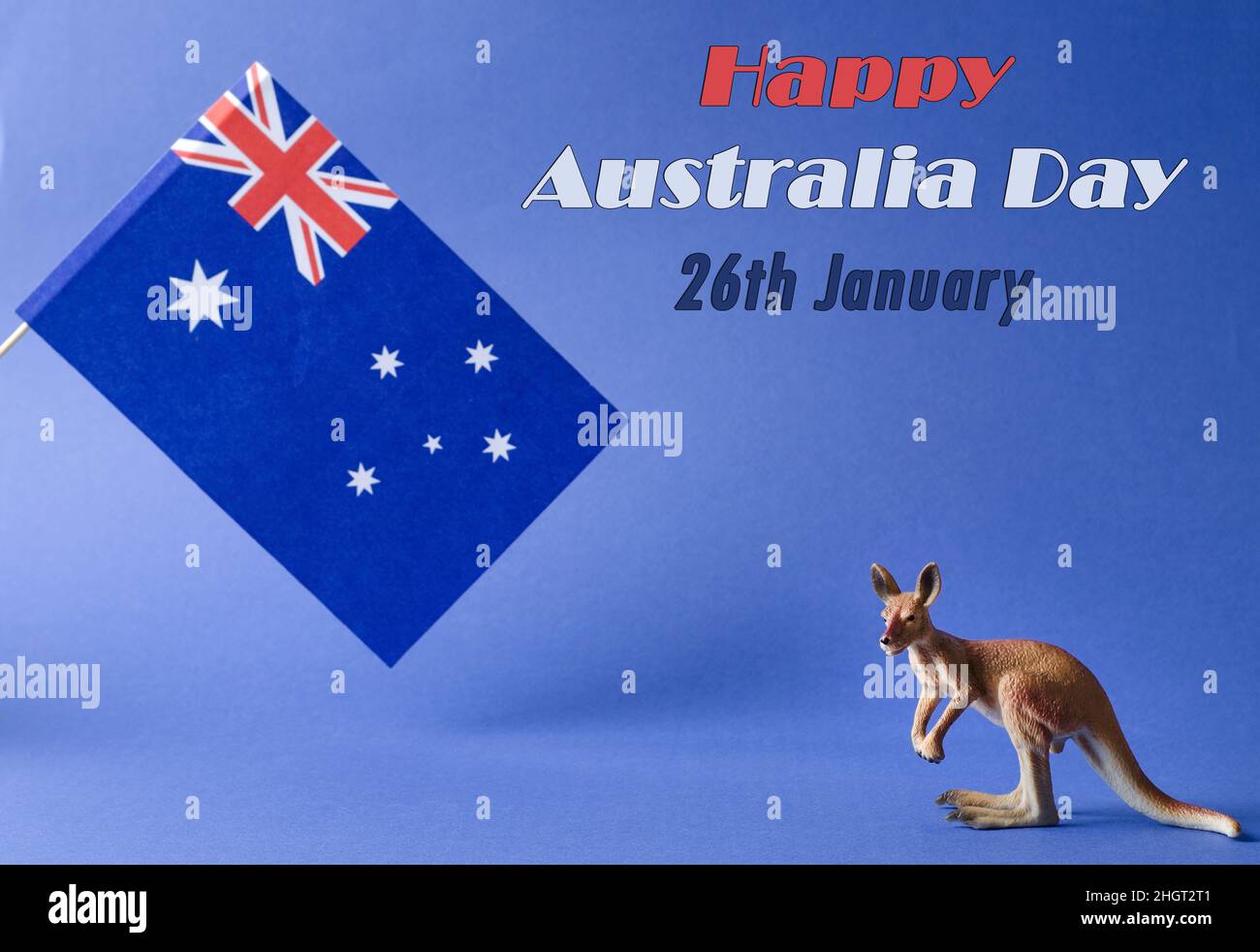 Am 26. Januar ist der Australia Day oder Anzac Day. Nationalflagge und Känguruh-Figur auf blauem Hintergrund mit der Inschrift des Happy Day of Australia Stockfoto