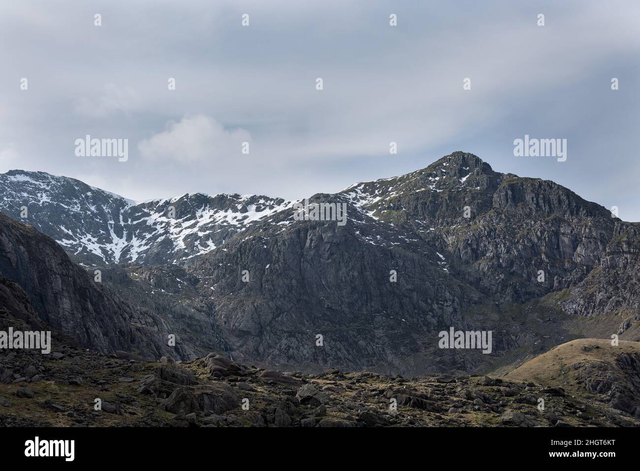 Gebirgskette mit dunklem Felsen in Snowdon mit schneebedeckten Gipfeln im Norden von wales Stockfoto